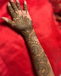 a woman's hand with henna tattoos on her left arm and the bottom half of