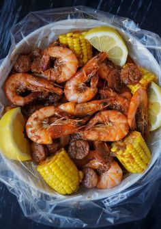 a bowl filled with shrimp and corn on the cob