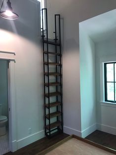 an empty room with a ladder leaning against the wall and a toilet in the corner