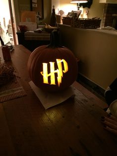 a pumpkin with the word hp carved into it sitting on a table in a room