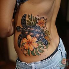 a woman's stomach with a turtle and flowers tattoo on her side ribcage