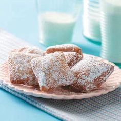 powdered sugar covered donuts on a plate