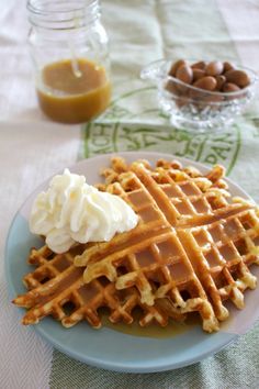 waffles on a plate with whipped cream and nuts