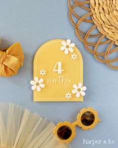 a birthday card with the number four on it next to some flowers and sun glasses