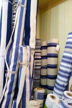 several rolls of blue and white striped fabric are stacked on top of each other in a closet