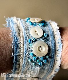 a close up of a person's arm wearing a bracelet with buttons on it