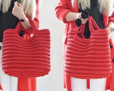 a woman is holding a red crocheted handbag in her hands and wearing white pants