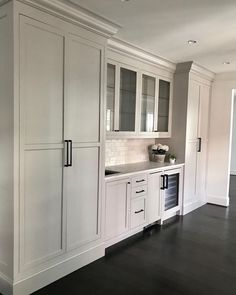 an empty kitchen with white cabinets and black flooring is pictured in this image from the front view