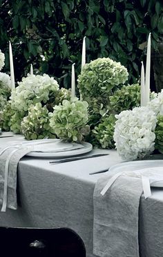 the table is set with white flowers and candles