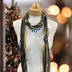 Discover this stunning bohemian beaded scarf necklace, crafted from luxurious Italian mohair yarn. The perfect lightweight accessory to elevate your holiday style. Features: Black and gold color combination Mohair yarn Italian craftsmanship Lightweight and comfortable Beaded details Linen gift pouch Benefits: Adds a touch of bohemian elegance to any outfit Perfect for the holiday season Luxurious and high-quality materials Versatile and can be worn in multiple ways Makes a thoughtful and stylish Handmade Black Scarves As Gifts, Bohemian Black Handmade Scarves, Bohemian Black Handmade Scarf, Bohemian Winter Festive Scarves, Bohemian Winter Scarves For Festive Occasions, Bohemian Handmade Scarves For Festive Occasions, Handmade Bohemian Scarves For Festive Occasions, Black Bohemian Scarf For Festive Occasions, Black Bohemian Scarves For Festive Occasions