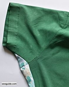 the bottom half of a pair of green pants with white flowers on them, and one piece of fabric that has been cut off