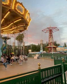 people walking around an amusement park at dusk