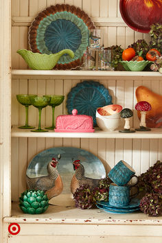 the shelves are filled with colorful dishes and other decorative items, including roosters on them