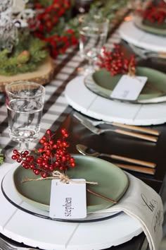 the table is set with plates and place settings for christmas dinner guests to eat at