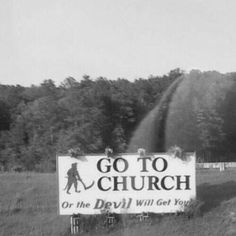 an old photo of a church sign on the side of a road with trees in the background