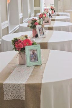 the tables are lined up with pictures and vases filled with pink flowers on them