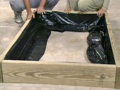 a person standing in front of a wooden box with plastic covering the bottom and sides