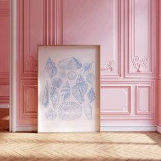 an empty frame on the floor next to a pink wall with seashells in it