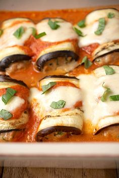 an enchilada dish is shown in a casserole dish on a wooden table