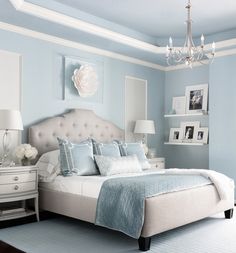 a bed room with a neatly made bed and a chandelier