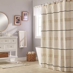 a bathroom with a sink, mirror and bathtub next to a white cabinet under a round mirror