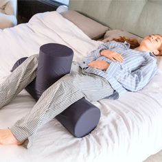 a woman laying on top of a bed next to pillows