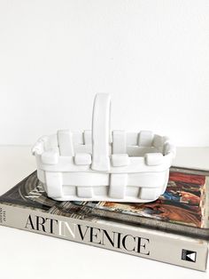 a book sitting on top of a table next to a white object that is shaped like a boat