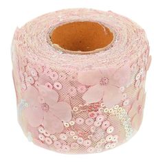 a roll of pink sequinized fabric with flowers on it