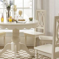 a white table and chairs in front of a window