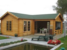 a small wooden house sitting next to a pond