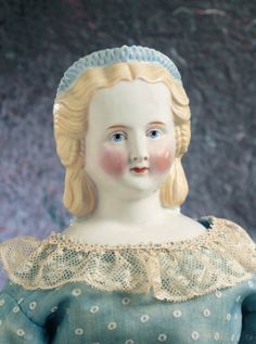 a doll with blonde hair wearing a blue dress