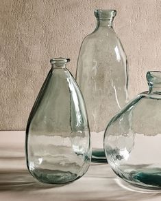 three glass vases sitting next to each other on a table