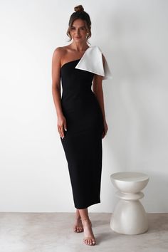 Highlights Elegant bodycon midi with white bow Soft, stretchy fabric Sizing The model is 5'10 and wears UK size 8 / S / US size 4 Fit & Fabric Made from 95% Polyester & 5% Spandex Rear zip Not lined True to size Length from top of shoulder to hem: 135cm Stretch: 7/10 Perfect for Wedding Guest Graduations Special occasions White Midi Dress With Bow For Party, Sleek One-shoulder Midi Dress For Party, Elegant Midi Dress, White Bow Midi Dress For Party, Fitted Bodycon Dress With Bow For Night Out, Black Fitted Dress For Black Tie Event, Ceremony Dress Guest, White Midi Dress With Bow For Evening, Modern One-shoulder Midi Dress For Party