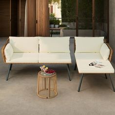 two white couches sitting next to each other on top of a cement floor covered patio