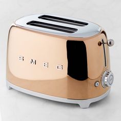 a toaster with the word smeg on it is sitting on a white surface