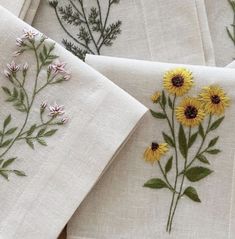 four embroidered napkins with flowers on them