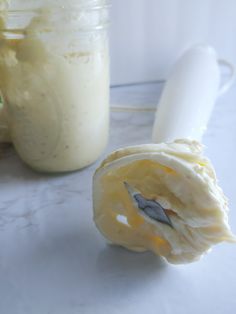 a jar filled with cream next to a spoon