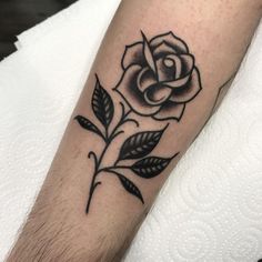 a black and white rose tattoo on the arm