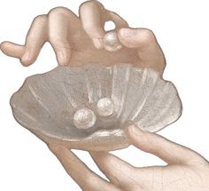 two hands holding a shell with pearls in it