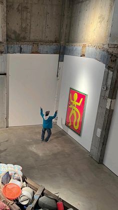 a man standing in an empty room with his arms up