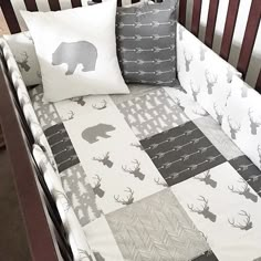 a crib bed with two pillows on top of it and an elephant pillow in the middle