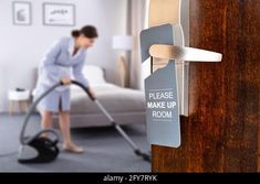 a woman is cleaning the floor with a vacuum