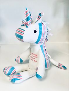 a stuffed unicorn sitting on top of a white table