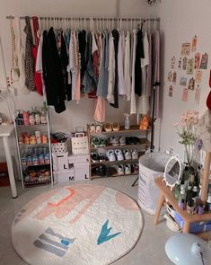 an organized closet with clothes hanging on the rack and other items sitting on shelves in front of it