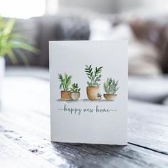 a card with three potted plants on it that says happy new home