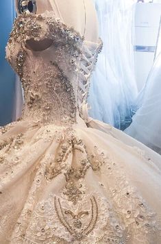 a wedding dress is displayed on a mannequin in front of some white dresses