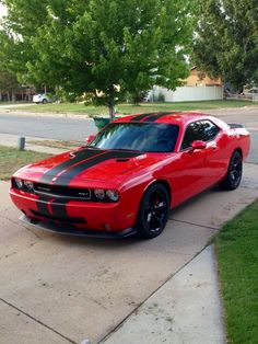 a red and black car parked on the sidewalk