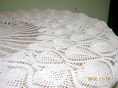 a white crocheted tablecloth on top of a bed