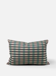 a green and brown pillow sitting on top of a white wall