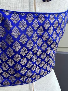 Brocade Royal Blue Color Readymade Blouse in Size 36 with padding. A dori or tie is added at the back of the blouse. Blouse has margin to open to size- 40 Item : BlouseSize : 36Color : Royal Blue Blouse Fabric : Brocade SilkBlouse Fitting : Princess Cut Lining : Yes, it is fully lined Padded or Non-Padded : Padded Closure: Front Closure with hooks.Ready-to-Wear : Yes Disclaimer - :-This is a Standard Size blouse. We do not guarantee perfect fit as every body and shape is different. Little or no Fitted Silk Blue Tops, Blue Fitted Silk Tops, Fitted Blue Silk Tops, Royal Blue Unstitched Blouse Piece For Festive Occasions, Fitted Blue Silk Blouse, Traditional Blue Tops For Party, Blue Padded Blouse For Wedding, Traditional Festive Blue Tops, Blue Party Tops With Tie Back